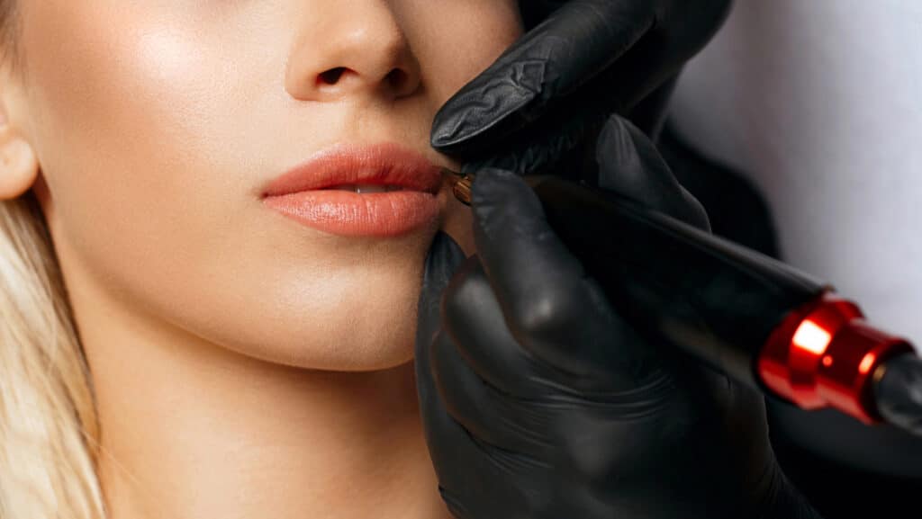 Close-up of the lip blush tattooing process showing gentle pigment layering for natural color.